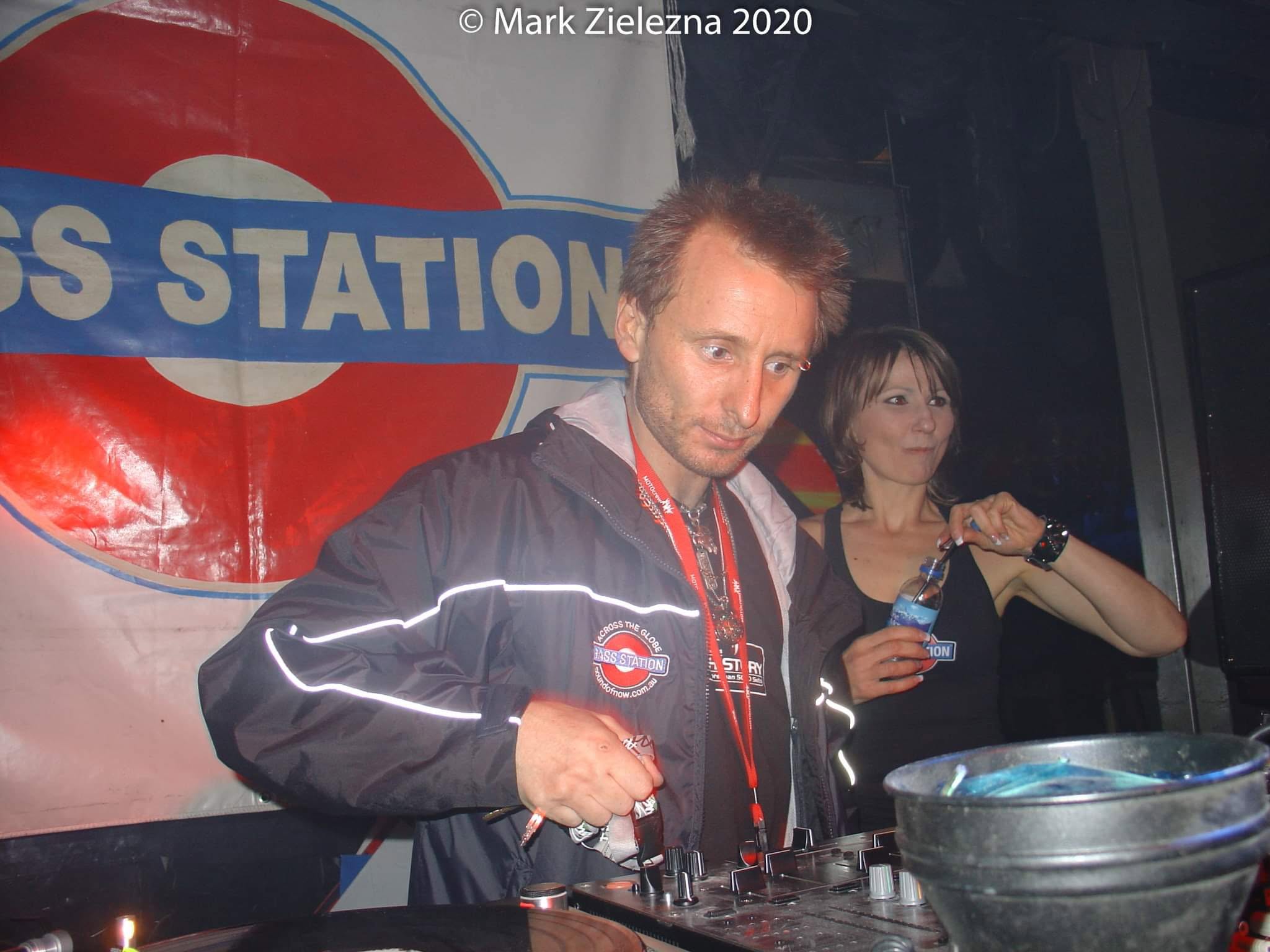 Old photograph of Jason Midro DJing in front of a Bass Station banner