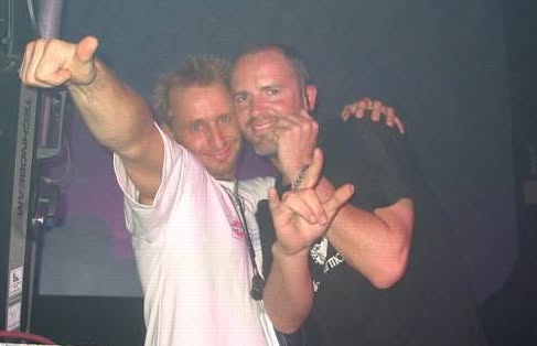 Two men on stage making a hand gesture together