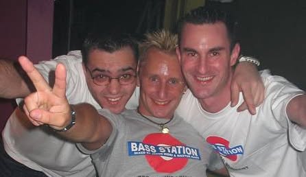 Three friends in white Bass Station t-shirts giving a peace sign