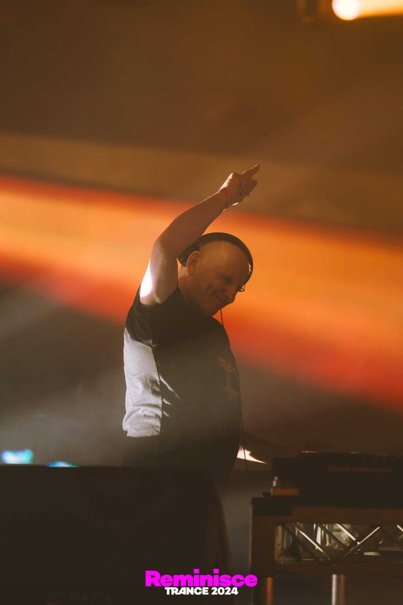 Jason Midro side profile, arm raised, warm stage lighting